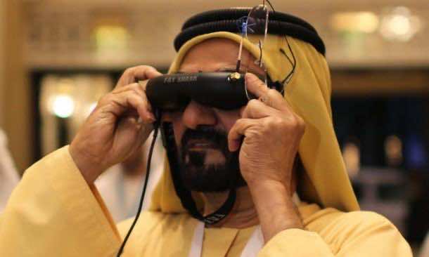 United Arab Emirates' Prime Minister and Ruler of Dubai Sheikh Mohammed bin Rashid al-Maktoum looks through a visor as he tests an unmanned aerial drone during Virtual Future Exhibition, in Dubai