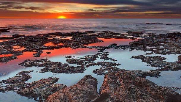 Tidal pools reflect the sunrise colors during the autumn equinox