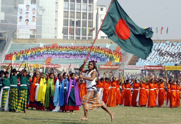 A school boy runs with a Bangladeshi flag during a performance to celebrate the 36th anniversary of Victory Day in Dhaka stadium December 16, 2007. Bangladesh won independence from Pakistan on this day following a nine month war in 1971. REUTERS/Rafiqur Rahman (BANGLADESH)