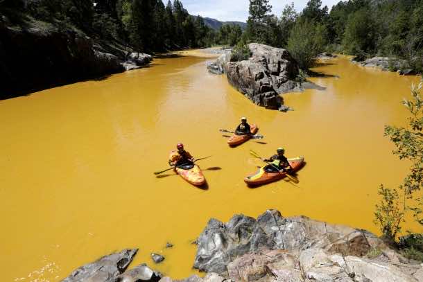 Aug. 6, 2015 - Durango, USA - People kayak in the Animas River near Durango, Colo., Thursday, Aug. 6, 2015, in water colored from a mine waste spill. The U.S. Environmental Protection Agency said that a cleanup team was working with heavy equipment Wednesday to secure an entrance to the Gold King Mine. Workers instead released an estimated 1 million gallons of mine waste into Cement Creek, which flows into the Animas River. (Jerry McBride/The Durango Herald via AP) MANDATORY CREDIT (Credit Image: © Jerry Mcbride/PA Wire via ZUMA Press)
