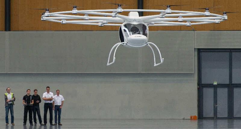 epa03958351 An unmanned electric powered vertical take-off aircraft called 'Volocopter' takes off during its presentation in the dm-Arena in Karlsruhe, Germany, 20 November 2013. The helicopter-like vehicle is propelled by electric motors and is either remotely controlled with a joystick or flying by autopilot. In a later stage of the development it is planned to have the aircraft capable to carry two people, their contructors Thomas Senkel, Stephan Wolf and Alexander Zosel said. EPA/UWE ANSPACH