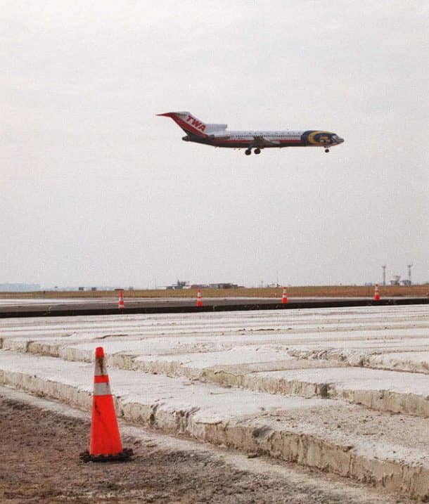 NEW YORK, UNITED STATES: A TWA aircraft flies over the newly-installed Foam Arrestor bed at the end of runway 4R-22L at John F. Kennedy International airport in New York 25 November. Designed to stop a large aircraft travelling at 75 knots, the bed is comprised of about 2,000 aerated cellular cement blocks. Total cost of design, construction and installation of the Foam Arrestor is 2.6 million USD. (Photo credit should read JON LEVY/AFP/Getty Images)
