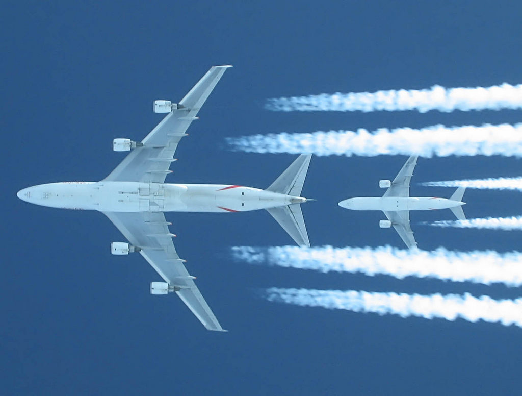 shot of this EK/Atlas Air 747 (2000ft above us) being chased by EK B777-200 (A6-EML, 4000ft above us) right at its tail. Captured out of a EK (now thats coincidence...) B777 flightdeck (through left #1 window upwards - thats why the neck was twisted ;-). Us at FL340, 747 at 360, other B777 at 380. Canon S50 max zoom.