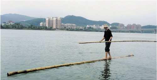 Chinese man bambooo crossing river